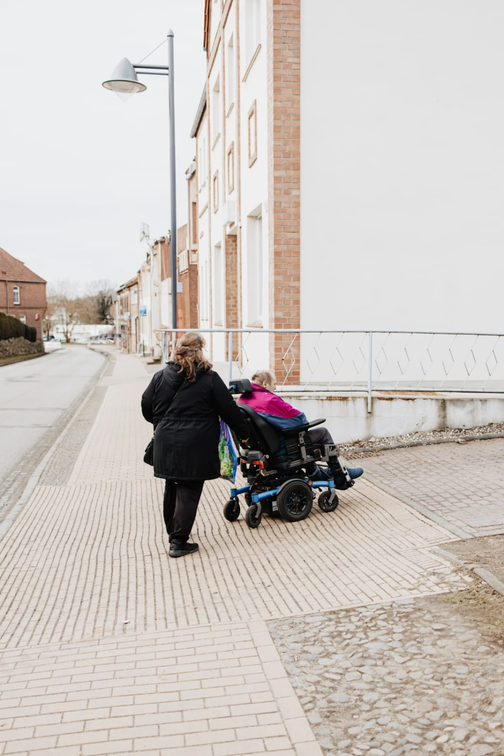 HeilOase Spiczak - eine Frau, die den Rollstuhl einer Seniorin schiebt