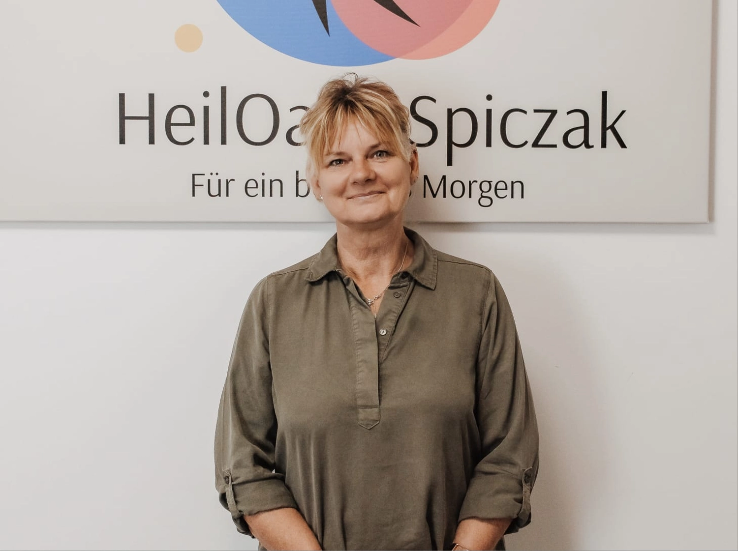 HeilOase Spiczak - Frau sitzt auf einem Schreibtischstuhl